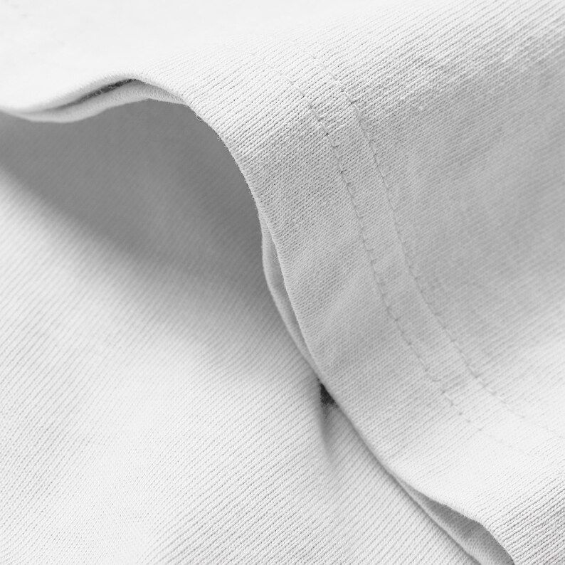 A close-up view of a white fabric, possibly a shirt or towel, with a slight crease visible.