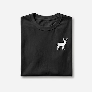 Puede incluir: Una camiseta negra de manga corta con un peque&ntilde;o gr&aacute;fico blanco de un ciervo de pie con astas, situado en la parte superior derecha del pecho. La prenda est&aacute; doblada cuidadosamente, mostrando un cuello redondo y un tejido negro liso.