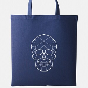 May include: A navy blue tote bag with a white geometric skull design.