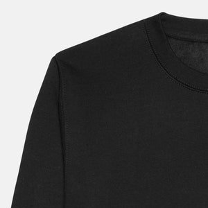 May include: Close-up of the neckline of a black sweatshirt. The fabric is soft and the stitching is neat.