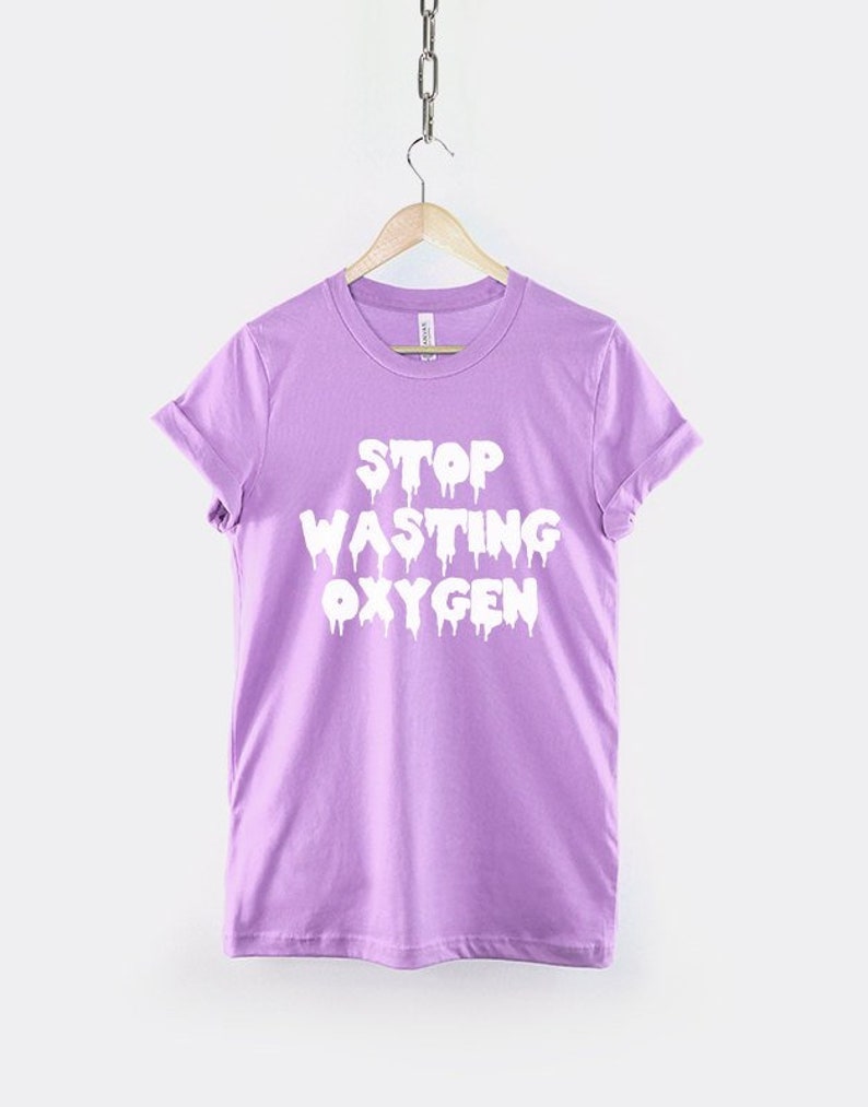 May include: A purple t-shirt with the text "STOP WASTING OXYGEN" in white dripping letters.