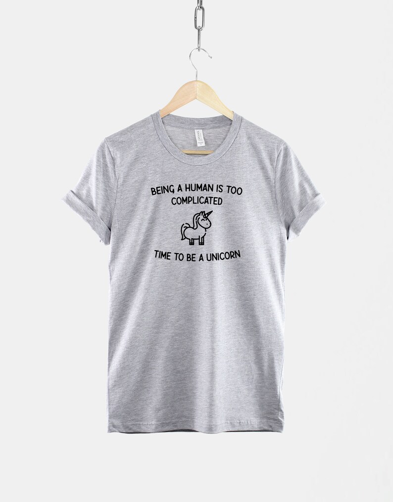 May include: Gray t-shirt with a black and white illustration of a unicorn and the text "Being a human is too complicated. Time to be a unicorn."