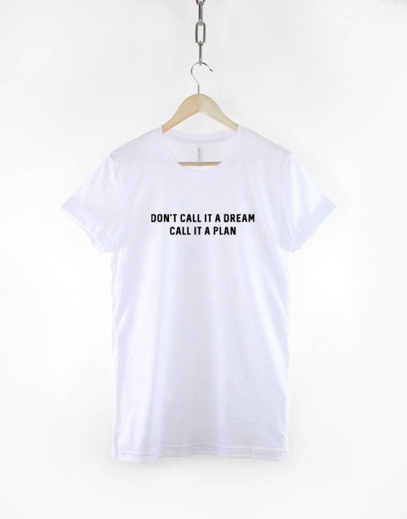 K&ouml;nnte beinhalten: Wei&szlig;es T-Shirt mit schwarzem Text, der "Nenn es nicht einen Traum, nenn es einen Plan" lautet.