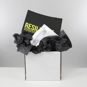 May include: A white ceramic mug with a black and yellow logo that says "RESILIENT" and the website address "www.resilientstreetwear.com". The mug is packaged in a white box with black tissue paper.