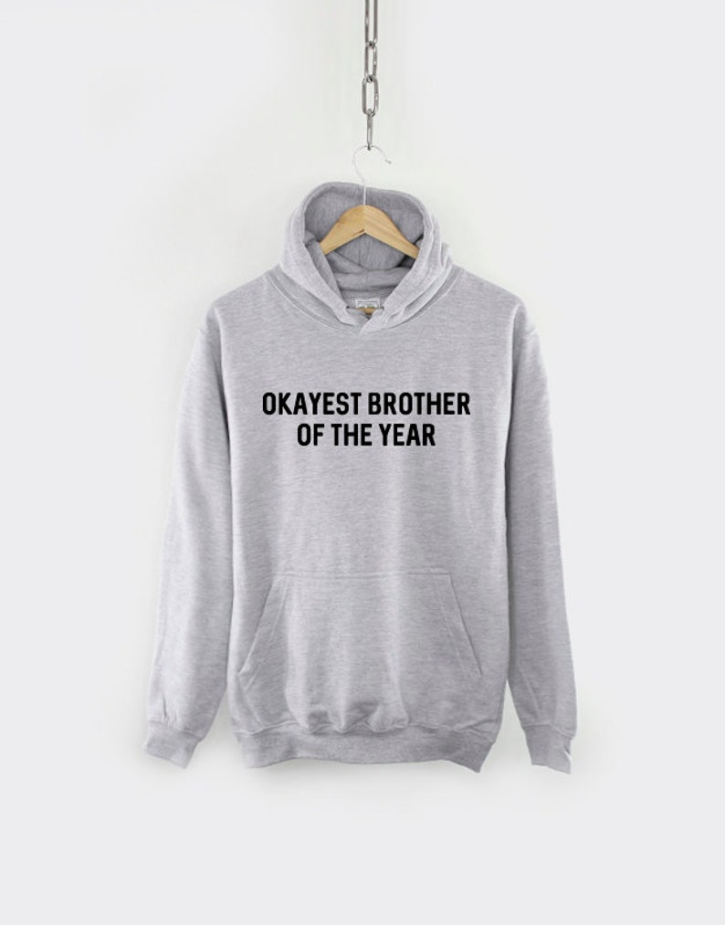 May include: A gray hooded sweatshirt with the text "Okayest Brother of the Year" printed in black.