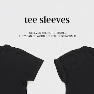 May include: Two black t-shirts with sleeves that are not stitched. The text "tee sleeves" and "Sleeves are not stitched. They can be worn rolled up or normal" is displayed above the shirts.