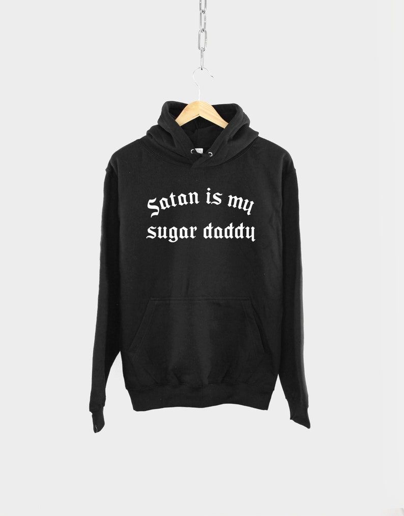 K&ouml;nnte beinhalten: Schwarzer Kapuzenpullover mit dem Text "Satan is my sugar daddy" in wei&szlig;er gotischer Schrift.
