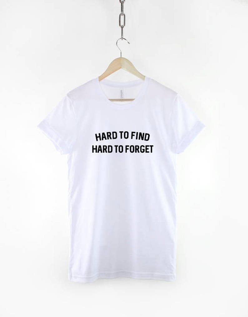 May include: White t-shirt with black text that reads "Hard to find Hard to forget".