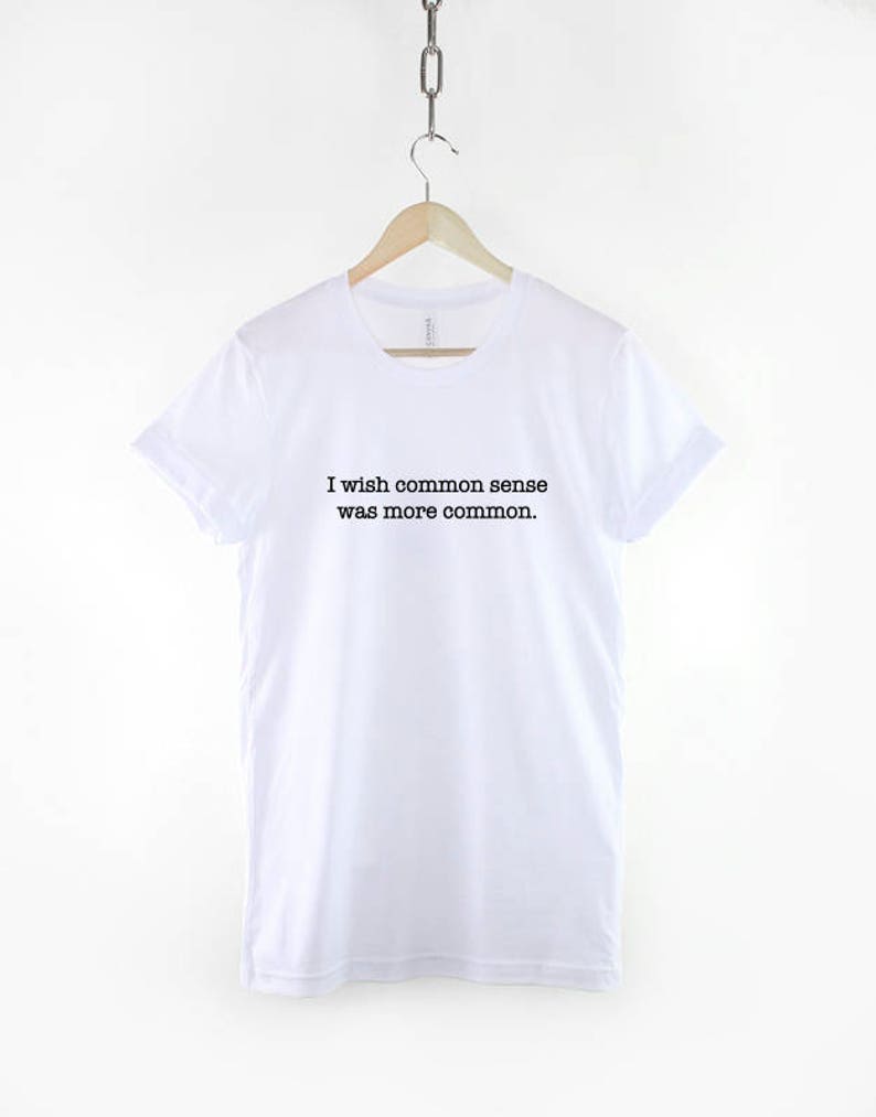 May include: White t-shirt with black text that reads "I wish common sense was more common."