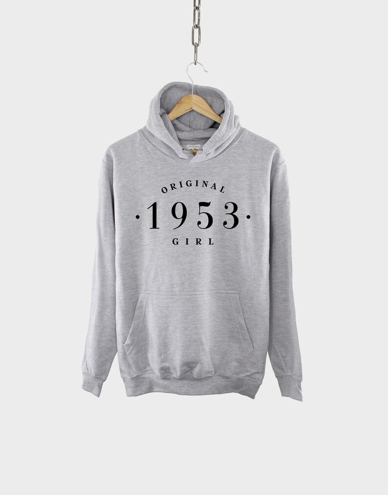 May include: Gray hooded sweatshirt with the text "ORIGINAL . 1953 . GIRL" printed on the front.