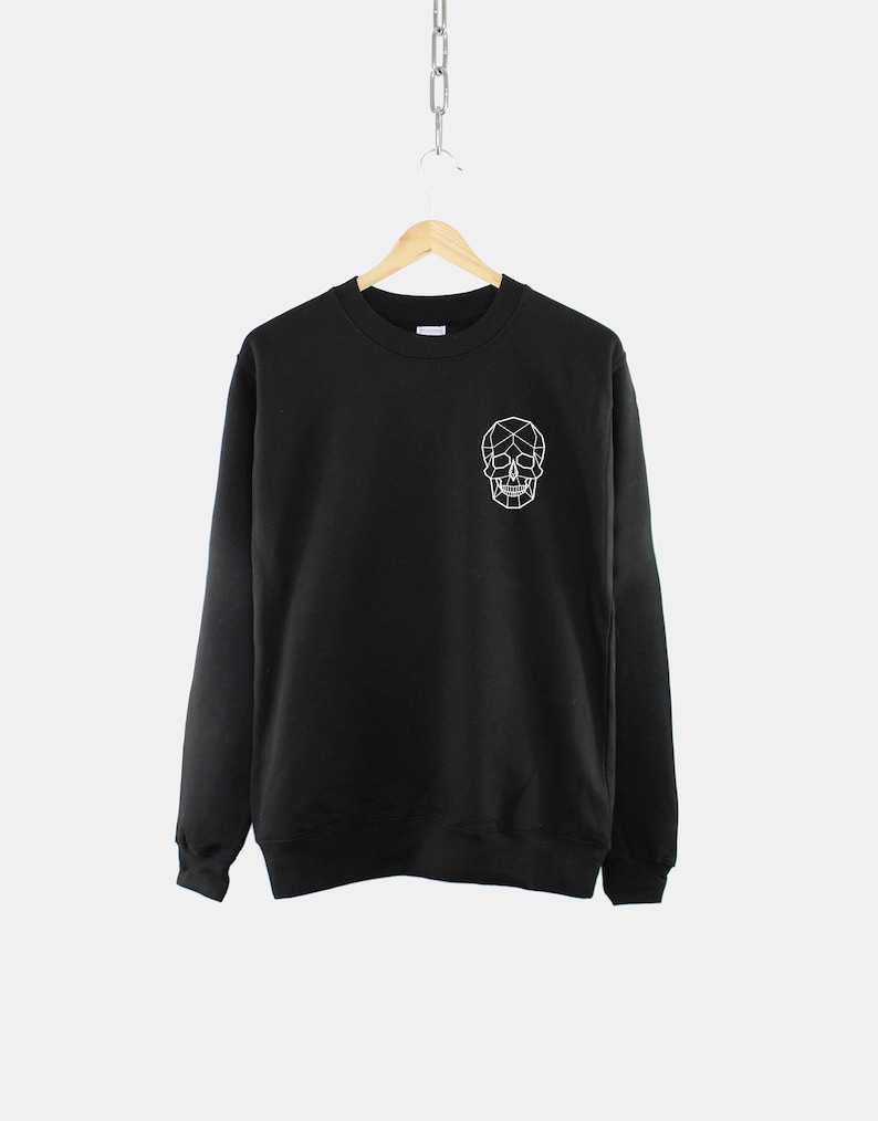 Puede incluir: Sudadera negra con un dise&ntilde;o de calavera geom&eacute;trica blanca en la parte delantera.