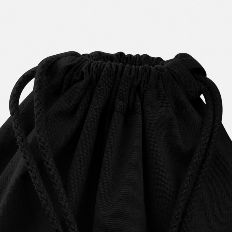 May include: Black drawstring bag made of canvas with a gathered top and long drawstrings.