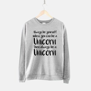 May include: Grey sweatshirt with black text that reads "Always be yourself unless you can be a Unicorn then always be a Unicorn".