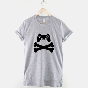 May include: A gray t-shirt with a black graphic of a video game controller and crossed bones.