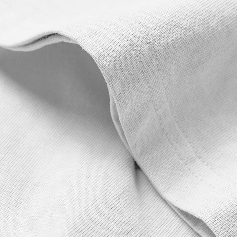 A close-up view of a white fabric, possibly a shirt or towel, with a slight crease visible.
