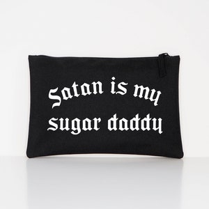Op de afbeelding: Zwarte canvas toilettas met witte gotische tekst "Satan is my sugar daddy".