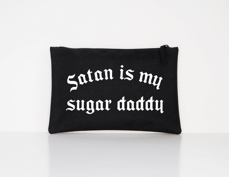 Op de afbeelding: Zwarte canvas toilettas met witte gotische tekst "Satan is my sugar daddy".