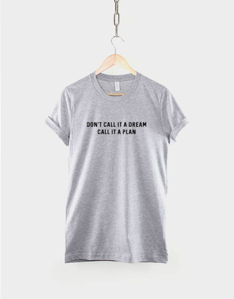 K&ouml;nnte beinhalten: Ein hellgraues T-Shirt mit dem Aufdruck "Don't call it a dream, call it a plan" in Schwarz.