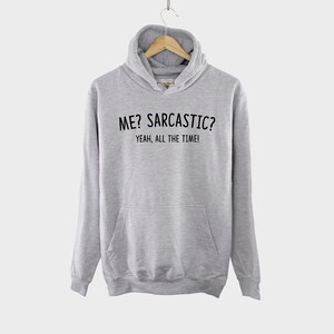 May include: A gray hooded sweatshirt with the text "ME? SARCASTIC? YEAH, ALL THE TIME!" printed on the front.