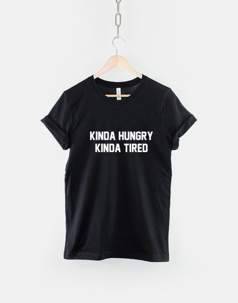 K&ouml;nnte beinhalten: Schwarzes T-Shirt mit wei&szlig;em Text, der "Kinda Hungry Kinda Tired" lautet.