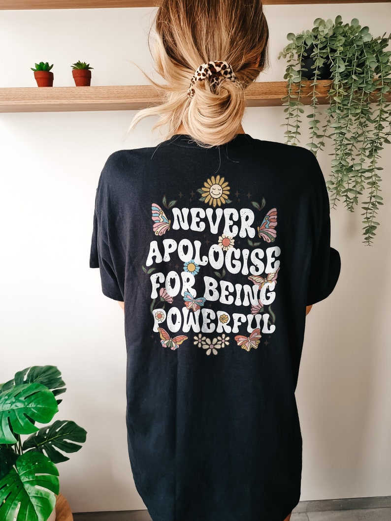 May include: Black t-shirt with a graphic print of butterflies, flowers, and the text "NEVER APOLOGISE FOR BEING POWERFUL".