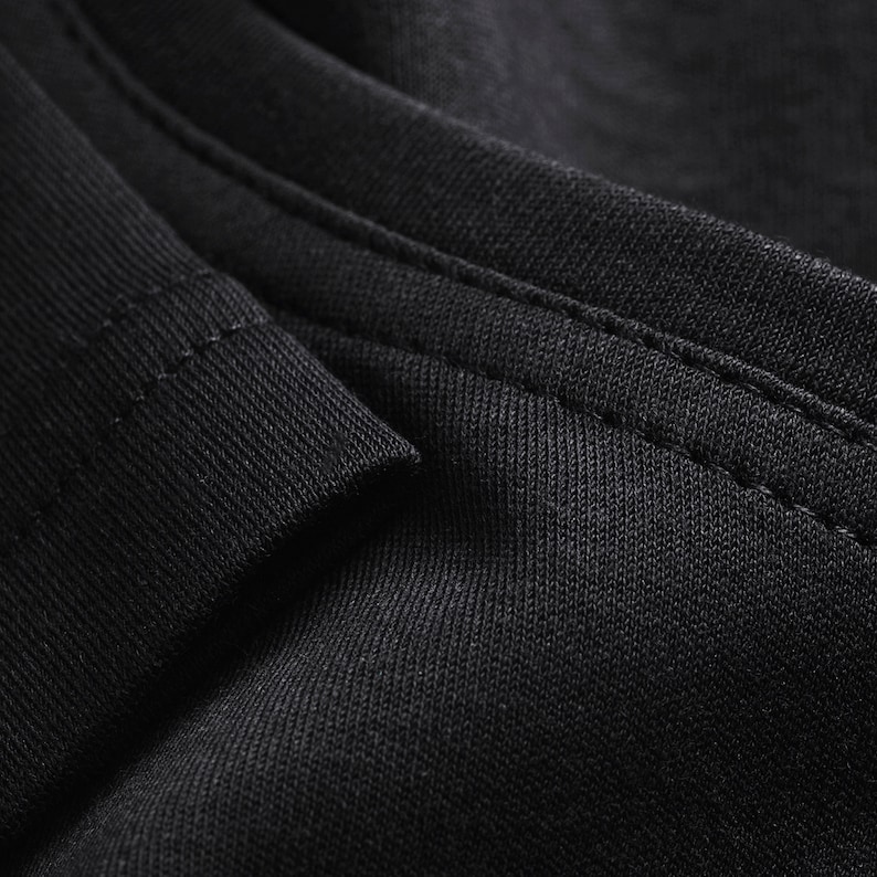 May include: Close-up of black fabric with a seam running along the edge.