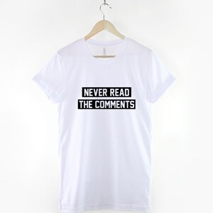 Puede incluir: Camiseta blanca con texto negro que dice "NUNCA LEAS LOS COMENTARIOS".