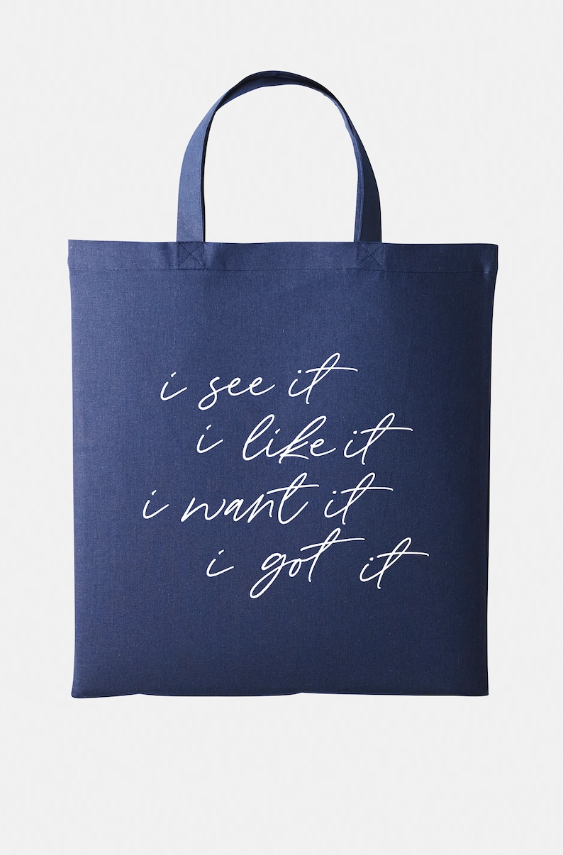 May include: A navy blue tote bag with white text that reads "i see it i like it i want it i got it".