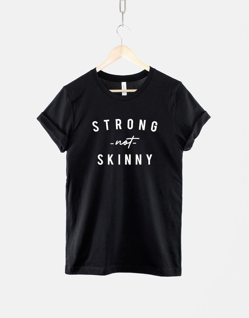 May include: Black t-shirt with white text that reads "STRONG -not- SKINNY".