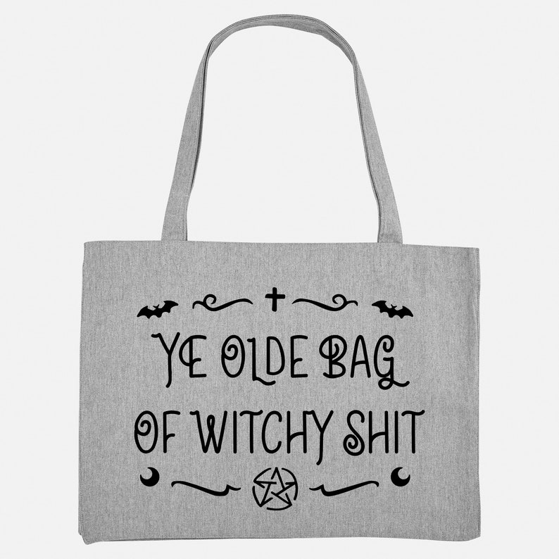 Puede incluir: Una bolsa de tela gris con el texto "Ye Olde Bag of Witchy Shit" en negro. La bolsa tiene una cruz negra, un pentagrama y dos murci&eacute;lagos.