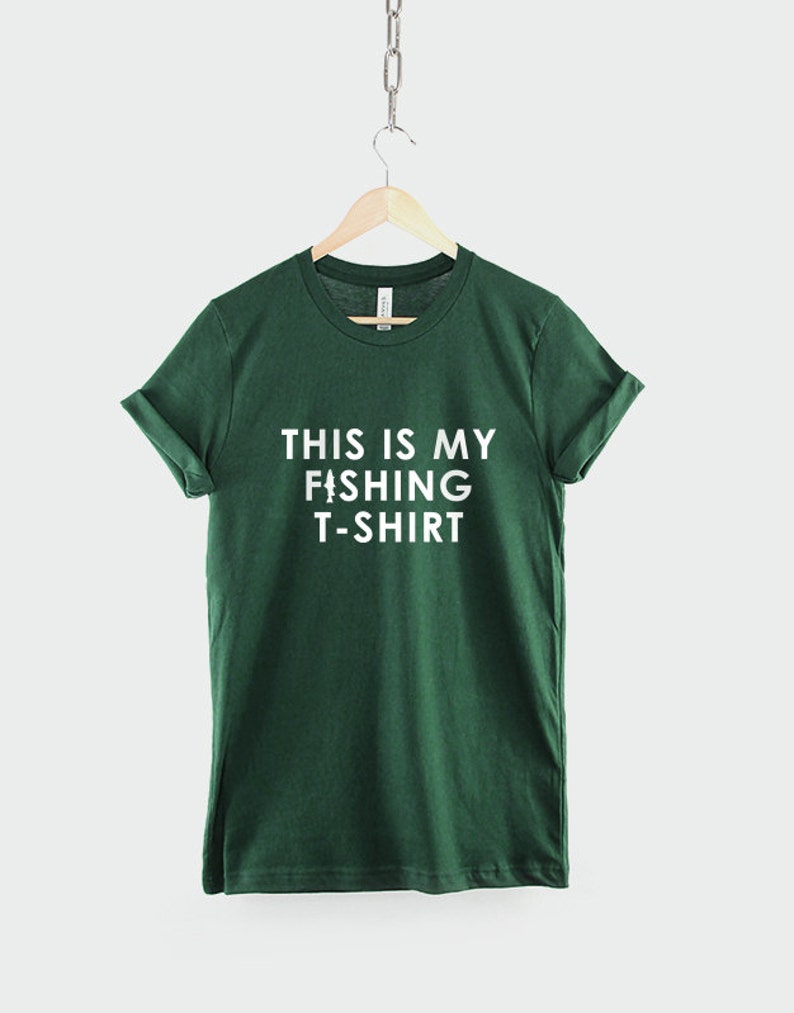 Może przedstawiać: Zielony T-shirt z białym napisem "This is my fishing t-shirt".