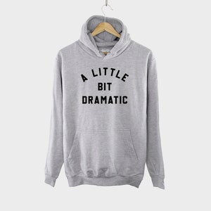 May include: A gray hooded sweatshirt with a black print that says "A LITTLE BIT DRAMATIC".