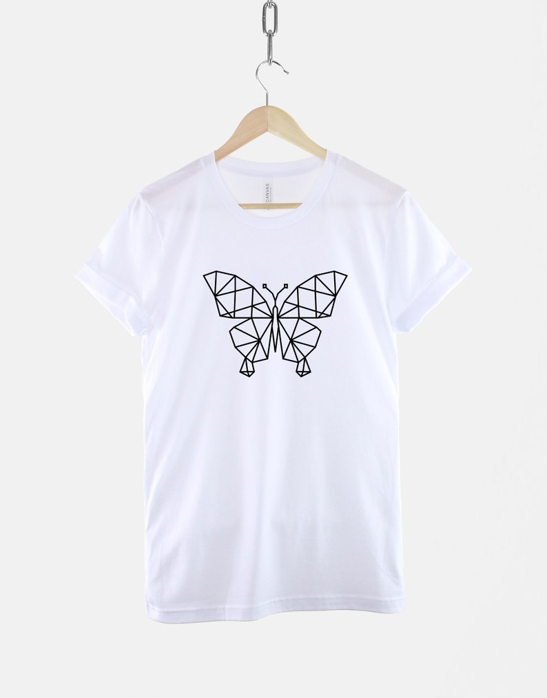 May include: White t-shirt with a black geometric butterfly design.