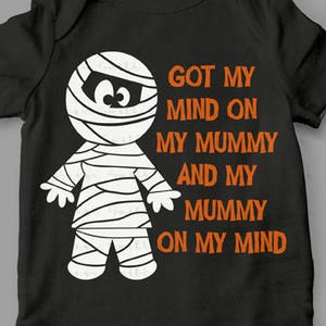 May include: A black onesie with a white mummy graphic and the text "GOT MY MIND ON MY MUMMY AND MY MUMMY ON MY MIND". The onesie is a digital SVG cut file.