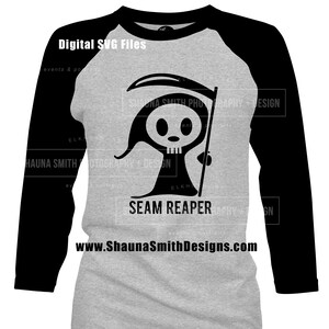 May include: A gray and black baseball t-shirt with a cartoon image of the Grim Reaper holding a scythe. The text "SEAM REAPER" is printed below the image. The website address "www.ShaunaSmithDesigns.com" is printed at the bottom of the shirt.