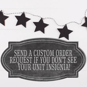 May include: Black chalkboard sign with white text that reads "Send a custom order request if you don't see your unit insignia!"  A string of black stars hangs above the sign.