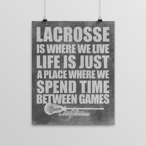 May include: A framed poster with the text "LACROSSE IS WHERE WE LIVE LIFE IS JUST A PLACE WHERE WE SPEND TIME BETWEEN GAMES." The poster has a distressed gray background and a lacrosse stick graphic.