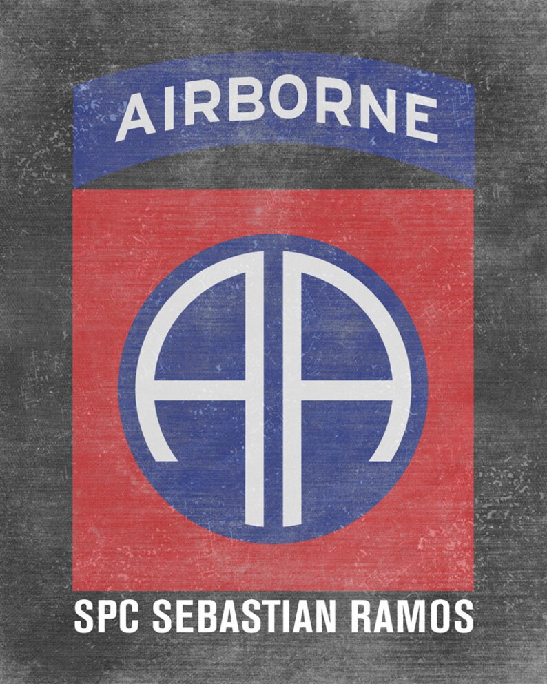May include: A red and blue military patch with the text "AIRBORNE" above a white circle with the letters "AA" inside. The text "SPC SEBASTIAN RAMOS" is below the circle.