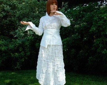 May include: A white, textured, long-sleeved shirt and skirt set with a fitted bodice and a flowing skirt.