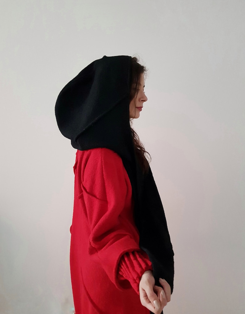 May include: A black hooded scarf with a long, flowing design. The scarf is made of a soft, warm material and is perfect for keeping warm in the winter.
