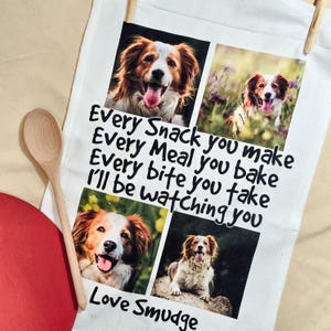 May include: White kitchen towel with four dog portraits and the text: "Every Snack you make, Every Meal you bake, Every bite you take, I'll be watching you. Love Smudge." The towel is hanging.
