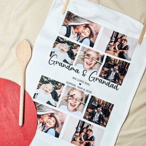 Könnte beinhalten: Weißes Küchentuch mit einer Collage von Familienfotos, darunter ein Paar, ein Baby und ein Kind mit Pinseln. Der Text lautet "Oma & Opa, Wir lieben euch, Sophie, Sam & Jess."
