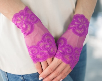 Könnte beinhalten: Ein Paar violette fingerlose Handschuhe aus Spitze mit Blumenmuster.