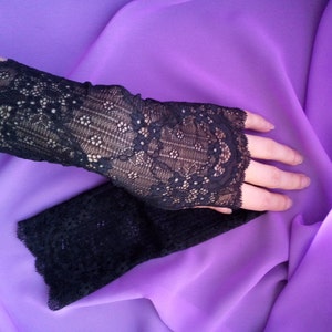 K&ouml;nnte beinhalten: Ein Paar schwarze fingerlose Handschuhe aus Spitze. Die Handschuhe sind aus zarter Spitze mit einem Blumenmuster.