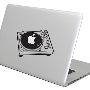 May include: A silver laptop computer with a black and white sticker of a turntable with an apple logo on the platter.