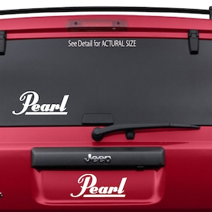 Puede incluir: Un Jeep rojo con una calcomanía de logotipo Pearl blanco en la ventana trasera. El texto "See Detail for ACTUAL SIZE" está impreso sobre el logotipo.