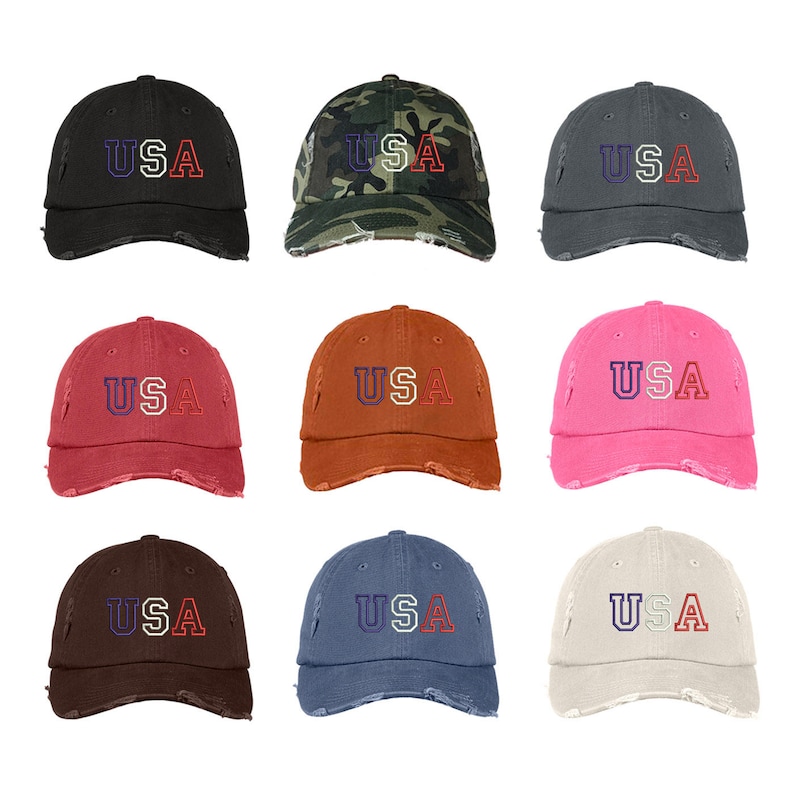 May include: Nine distressed baseball caps in various colors, each featuring the word "USA" in red, white, and blue embroidered lettering. The caps are arranged in three rows of three.