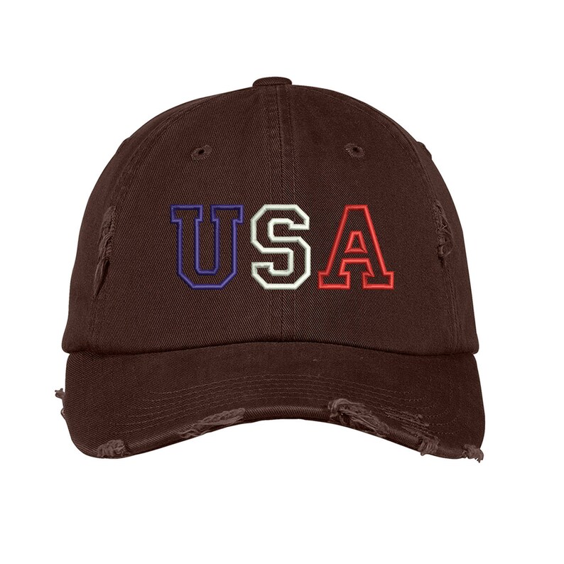 May include: A brown distressed baseball cap with the word "USA" embroidered in blue, white, and red.