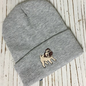 May include: Gray knitted beanie with a brown and tan embroidered pug design.