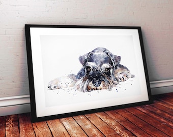 May include: Watercolour painting of a Schnauzer dog in a black frame. The dog is depicted in shades of grey, black, and brown, with a long, shaggy beard. The artwork is displayed on a white background, leaning against a white brick wall and a wooden floor.
